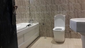 Un baño con bañera, inodoro y lavamanos.