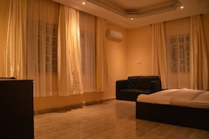 Una habitación de hotel con una cama, un sofá y cortinas.