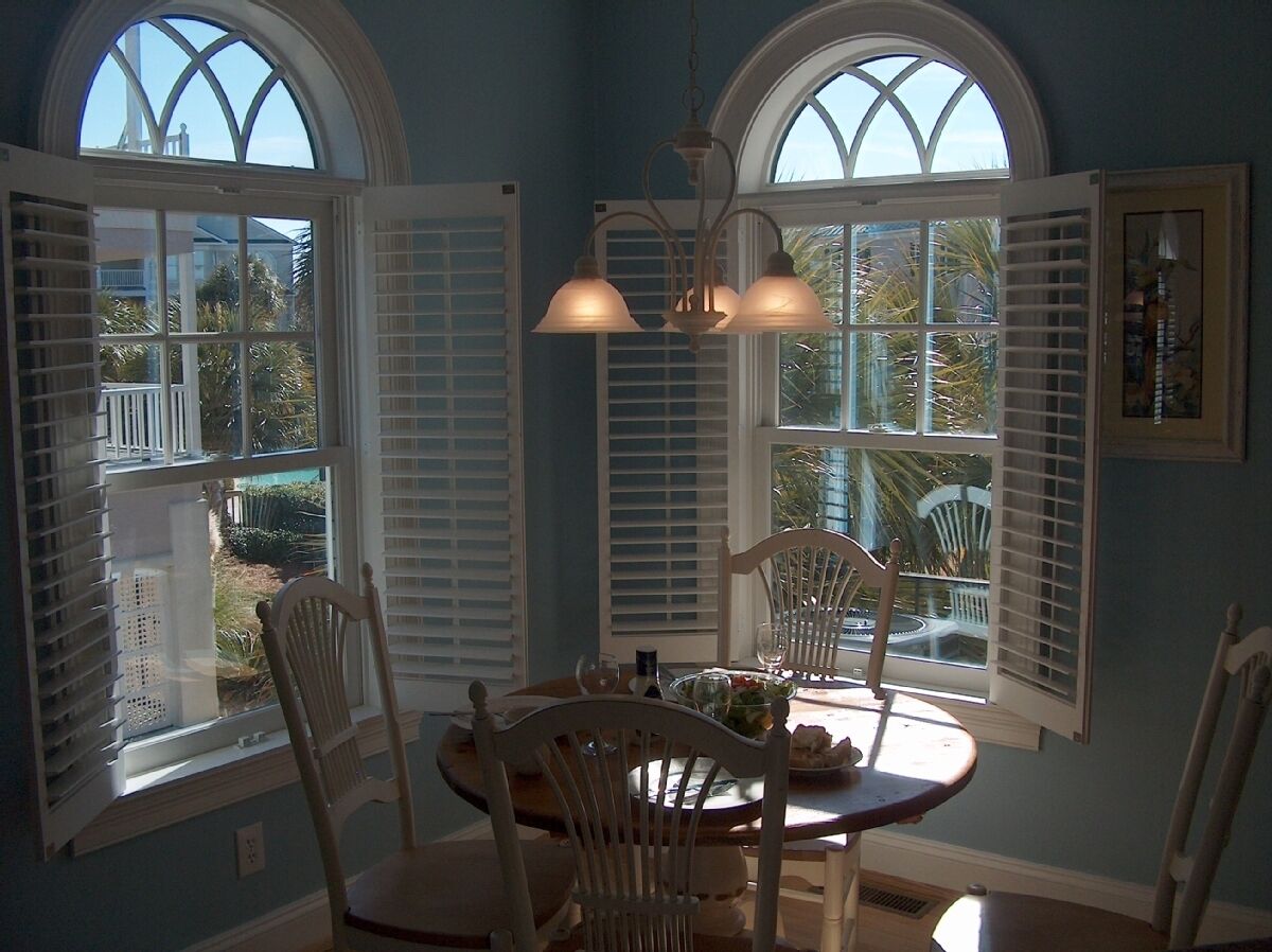A dining area with a table, chairs, and a chandelier.