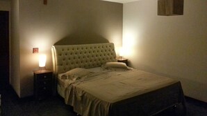 A bedroom with a large bed, two bedside tables, and a hanging light fixture. - House in a gated community in Barra da Tijuca  (RIO DE JANEIRO)