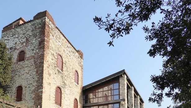 Un bâtiment historique en pierre, doté d’une grande fenêtre et d’une plus petite fenêtre sur le côté.