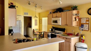 A compact kitchen with a microwave, sink, and a small dining area. - Newly Updated Spacious 3 Bedroom Home With Pool, - near Disney (Davenport)