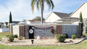 A sign for Santa Cruz Community with a palm tree and decorative wreaths. - Newly Updated Spacious 3 Bedroom Home With Pool, - near Disney (Davenport)