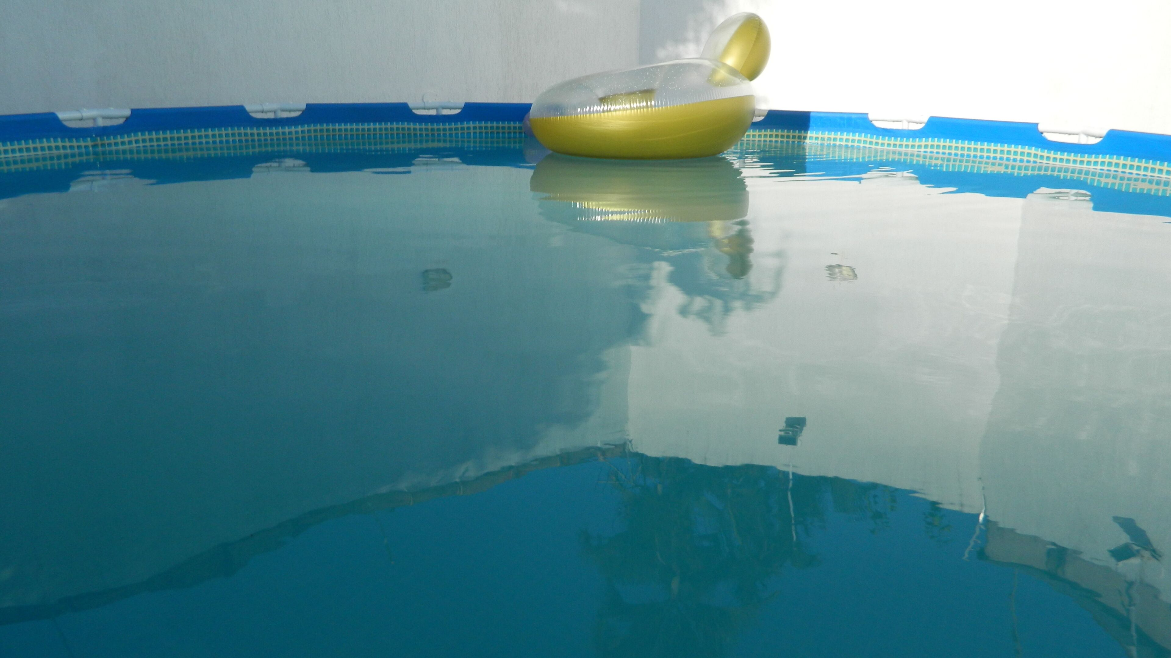 Une piscine intérieure à eau claire avec un ballon jaune gonflable.