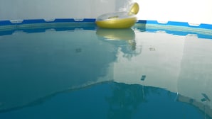 Une piscine intérieure à eau claire avec un ballon jaune gonflable.