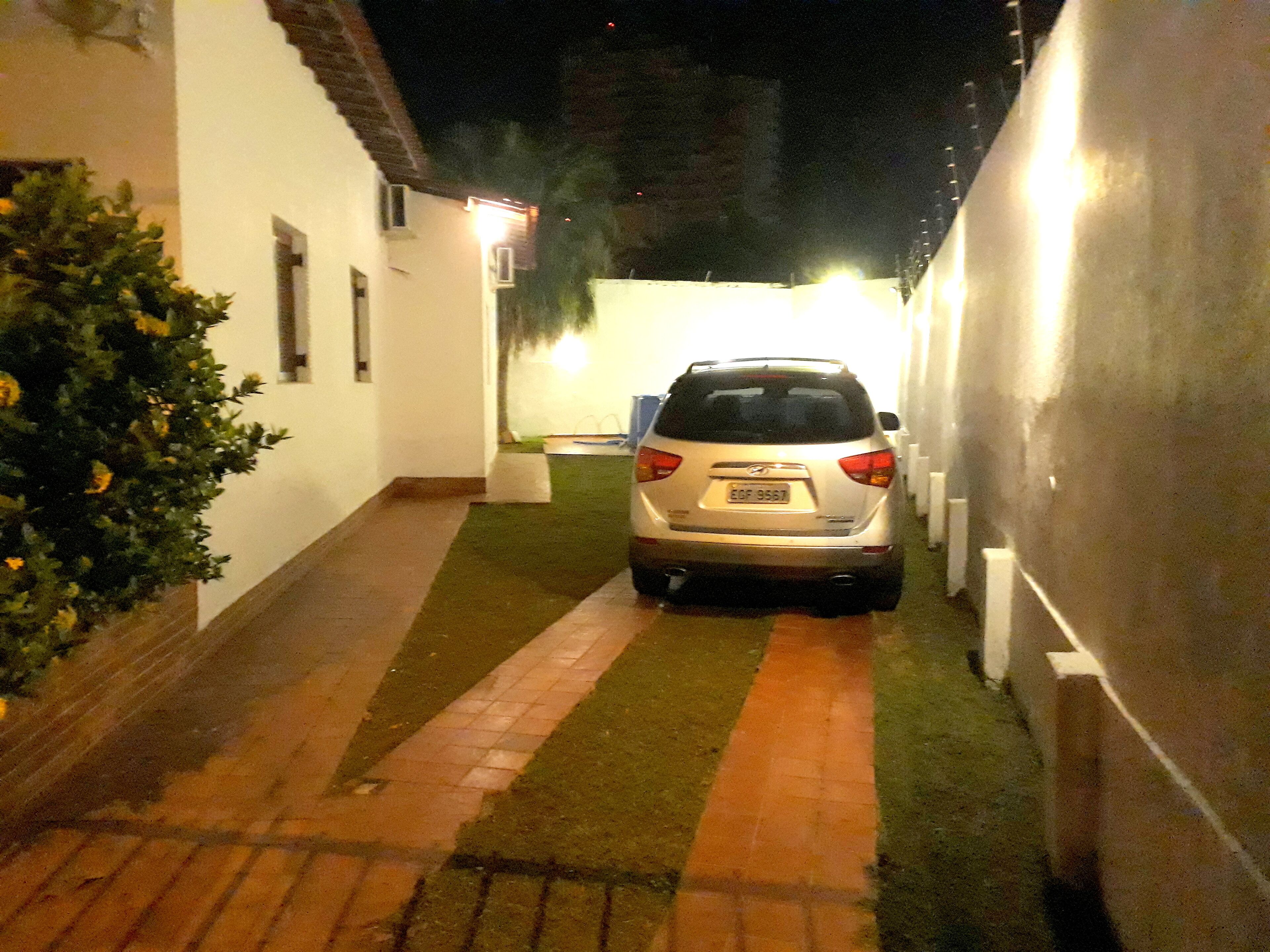 Stretto vialetto che porta a un'auto parcheggiata in zona residenziale.