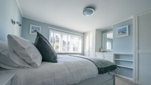 A bedroom with a bed, a window, a bedside table, and a wardrobe. - Charming 2 bedroom cottage in Lymington, very close to town, marina & sea walks (Lymington)
