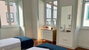 A hotel room with two beds, a dresser, and a mirror. - Kings' Retreat   (Horta)