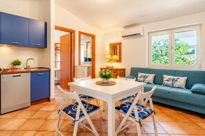 Un espace de vie compact comprenant une kitchenette, un coin repas et un canapé avec vue.