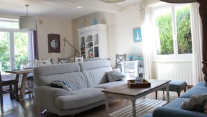 Una sala de estar con un sofá gris, una mesa de centro de madera y un mueble blanco con adornos.
