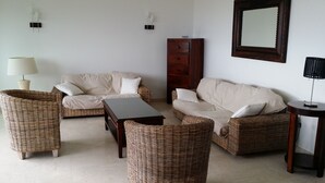 A living room with wicker furniture, a wooden cabinet, and a mirror on the wall. - Apart. w/ panoramic sea view facing beach for 6 people, Saint-Georges-de-Didonne (Saint-Georges-De-Didonne)