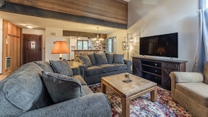 A spacious living room with a large sectional sofa, a coffee table, and a flat-screen TV. - Sunrise15: close to Snowcreek Golf Course (Mammoth Lakes)