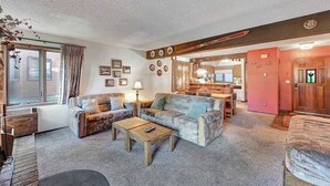 Ein gemütliches Wohnzimmer mit Sofa, Couchtisch und einer Essecke mit Tisch und Stühlen.