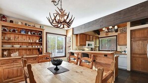Una cocina amplia con armarios de madera, una isla central y una araña.