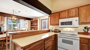 Una cocina con armarios de madera, una estufa blanca y un microondas.