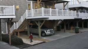 A two-story house with a balcony, a staircase, and a car parked in the driveway. - Gorgeous home perfect for large groups and only steps to the beach access. (myrtle beach)