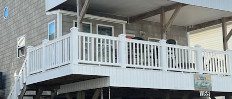 A two-story building with a balcony and a covered area.
