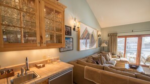 A kitchen with a built-in sink, wooden cabinets, and a glass display case. - Spacious ski in double condo prime base area location by Mountaineer Square.   (Mt. Crested Butte)