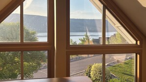 A room with a large skylight window offering a view of a lake and surrounding greenery. - Amazing unobstructed Lake Okanagan view - Booking for summer 2026 now! (Kelowna)