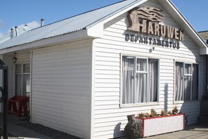 Un edificio blanco con un cartel que dice "HARUWEN DEPARTAMENTOS".