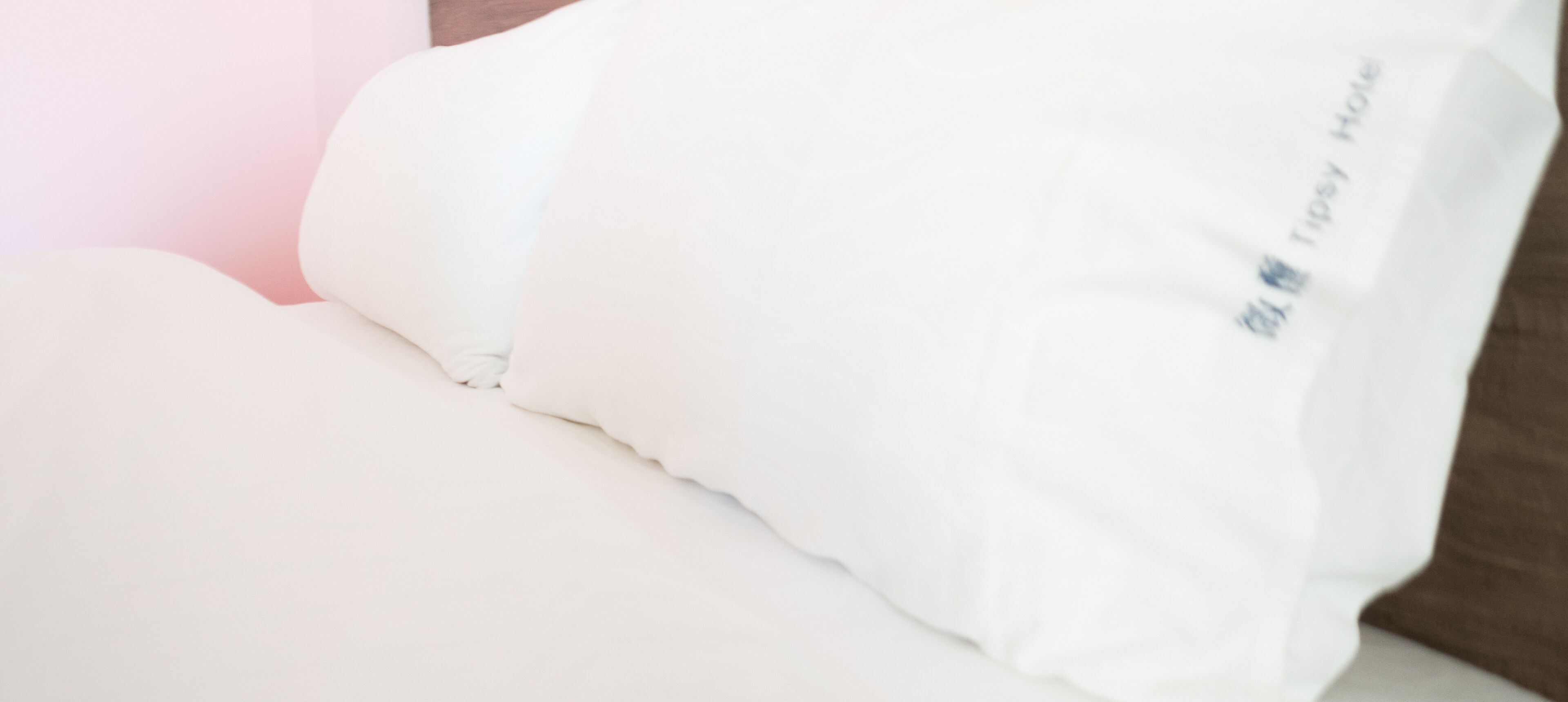 A white pillow with a tag that reads "Tipsy Hotel".