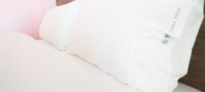 A white pillow with a tag that reads "Tipsy Hotel". - TipsyHotel (Jincheng)