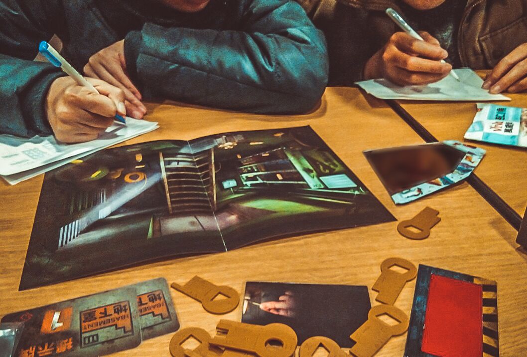 Una mesa con papeles, una revista y algunas figuras recortadas.