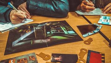 Una mesa con papeles, una revista y algunas figuras recortadas.
