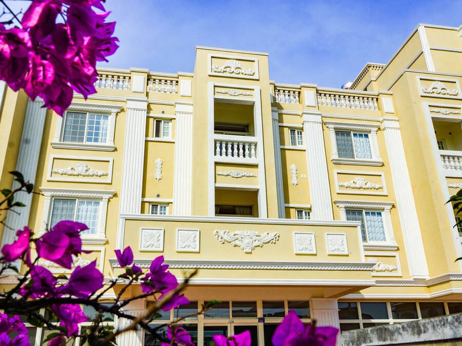 A yellow building with balconies and decorative moldings.