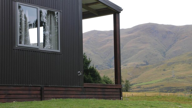 A modern building with a large window and a porch overlooking a mountainous landscape. - Alpine Views Burkes Pass (Burkes Pass)