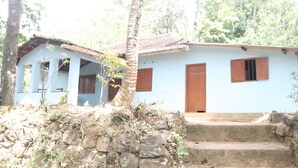 A light blue building with a tiled roof, wooden doors, and windows. - Mahagedara Home Stay (Laggala-Pallegama)