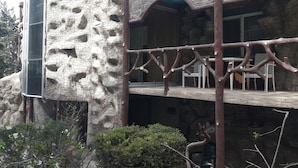 Un edifici amb façana rugosa i amb relleu, i un balcó amb caires.