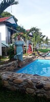 Una piscina al aire libre, sillones reclinables de piscina