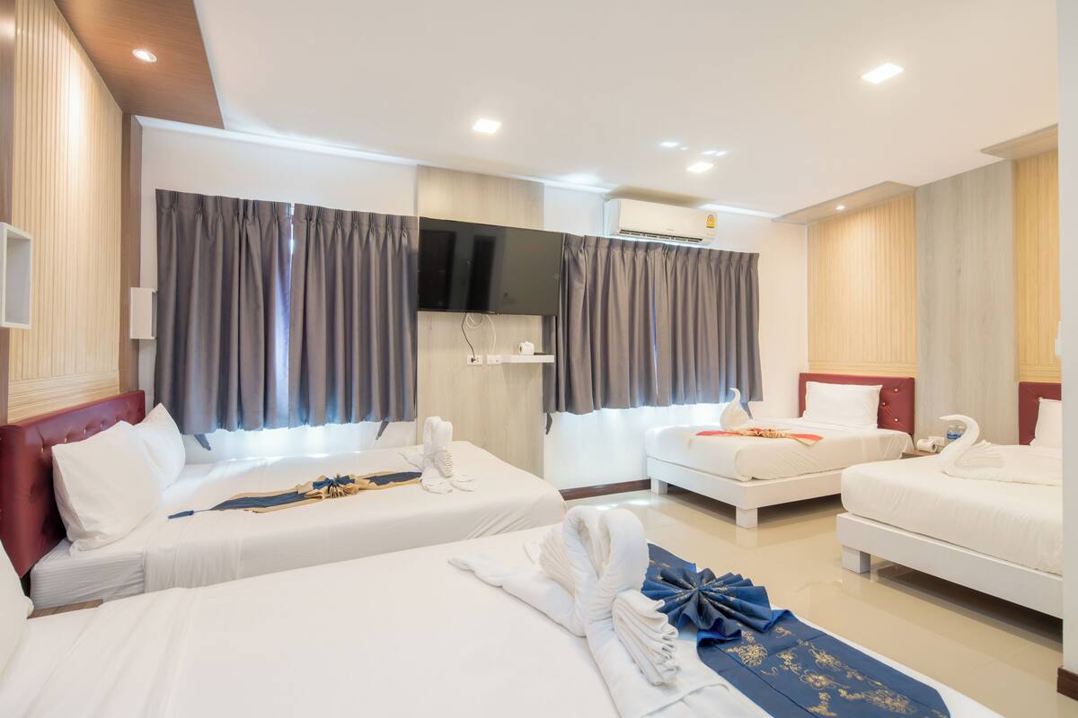 Una habitación de hotel con dos camas, una televisión de pantalla plana, aire acondicionado y un minibar.