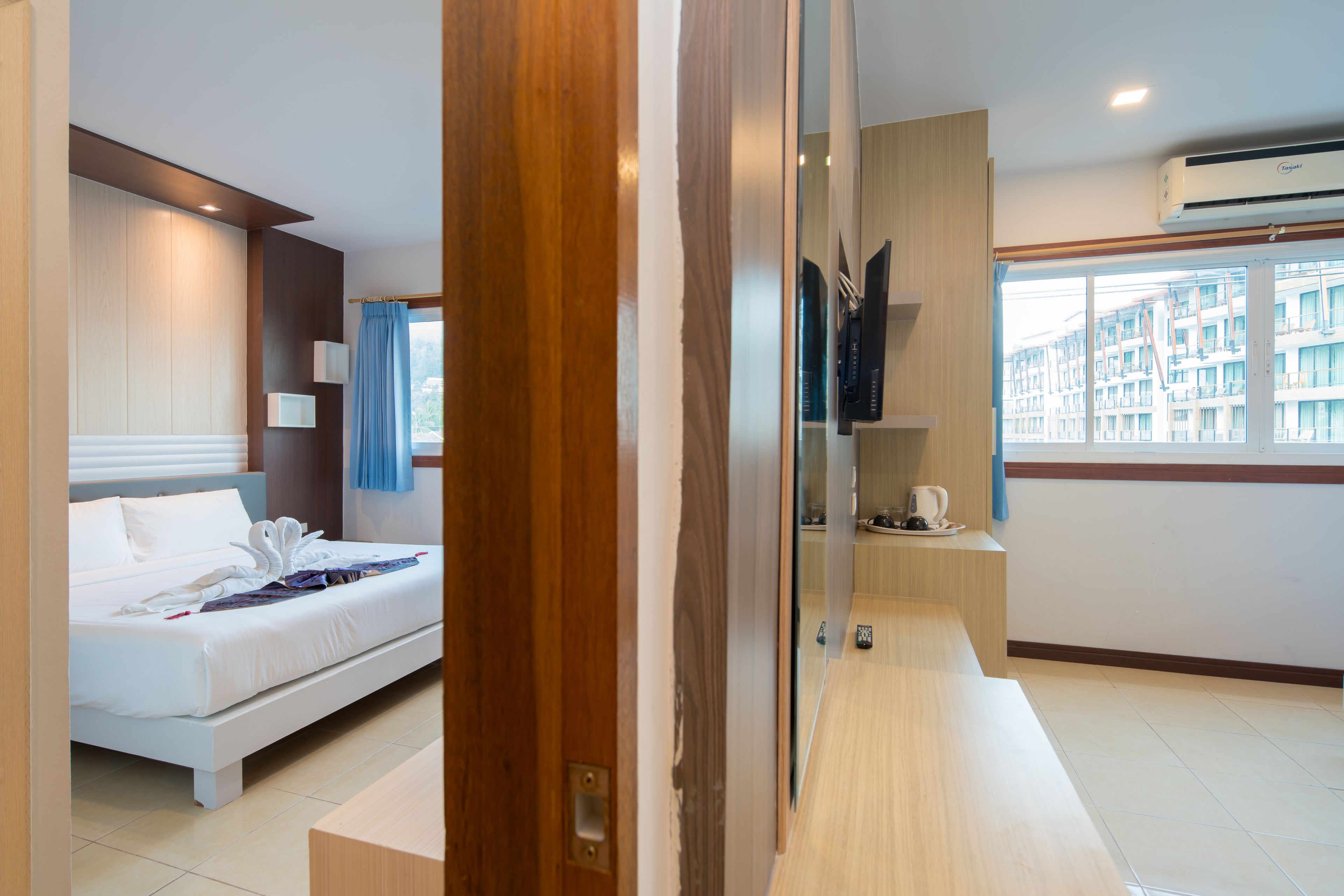 Habitación de hotel moderna con cama, escritorio y vista a la ciudad por la ventana.