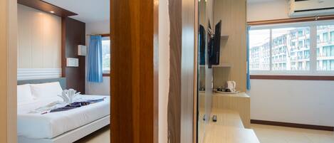 Habitación de hotel moderna con cama, escritorio y vista a la ciudad por la ventana.