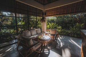 Una habitación amplia con un ventanal grande, un sofá, una mesa y sillas.