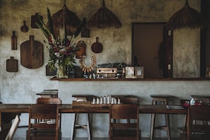 Un coin bar au style rustique, avec des meubles en bois, une machine à café et une plante décorative.