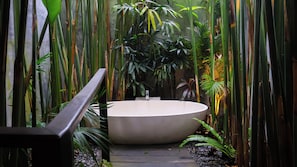 A circular pool with a modern design, surrounded by tall bamboo plants and other greenery, with a concrete pathway leading to it. - The Hidden Paradise Ubud (Ubud)
