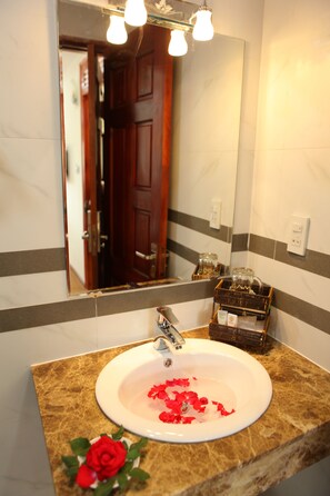 A bathroom with a marble sink, a mirror, and a door in the background. - Hong Tung Hotel (Xuan Huong - Da Lat)