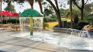 Un espace piscine agrémenté d’un élément aquatique, comprenant une fontaine et une structure décorative.