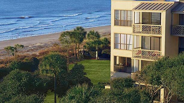 Un bâtiment situé sur la côte, doté d’un balcon donnant sur la plage et l’oc éan.
