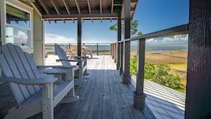 A wooden deck with Adirondack chairs and a view of the ocean. - 'Forcynthia' Luxury Bay Home 4BR/4.5BA ,w/ dock, kayak launch (St. George Island)