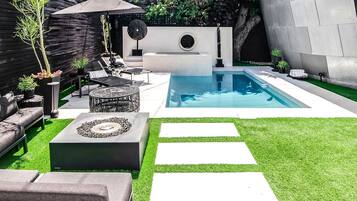 Relax by the pool surrounded by lush greenery and a unique sculpture.