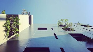 Una terraza en la azotea con un diseño minimalista, con patrones geométricos y plantas en macetas.