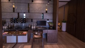 Una cocina moderna con estación de café integrada, televisor de pantalla plana y rincón de descanso con banco acolchado.