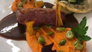 Ein Teller mit einem Steak, Kartoffelpüree, Erbsen und einem Salat.