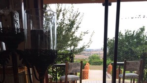 A room with a view of the outdoors, featuring a table with a glass bowl and a vase with a rose. - Hotel Le Palais d hotes (Salé)