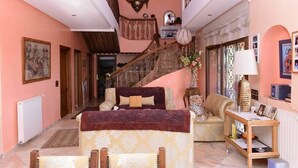 A spacious living area with a staircase, a sofa, a coffee table, and a lamp. - Hotel Le Palais d hotes (Salé)