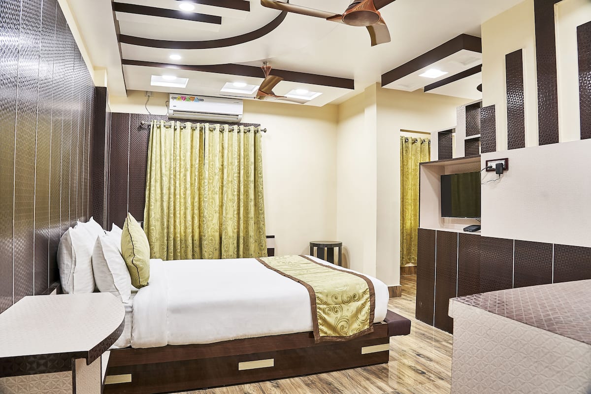 Una habitación de hotel con cama, mesita de noche y una pequeña mesa redonda.